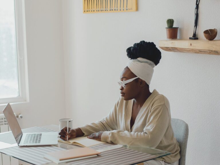 Woman journaling at a table while learning how to rebuild self-trust after divorce.